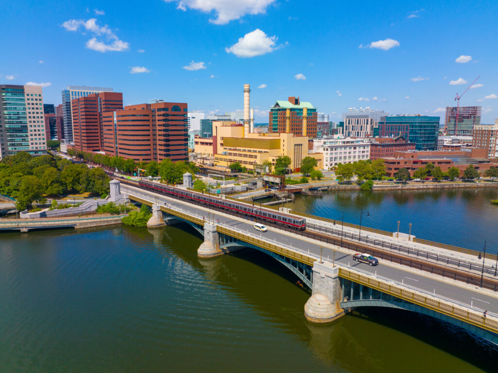 Cambridge Kendall Square skyline and MBTA red line train on Longfellow Bridge aerial view, Boston, Massachusetts MA, USA. The bridge connects Cambridge and Boston over Charles River.